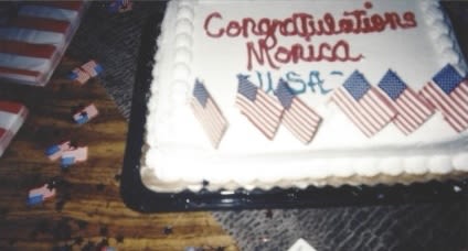 A cake that reads "Congratulations Monica USA" with little American flags on top.