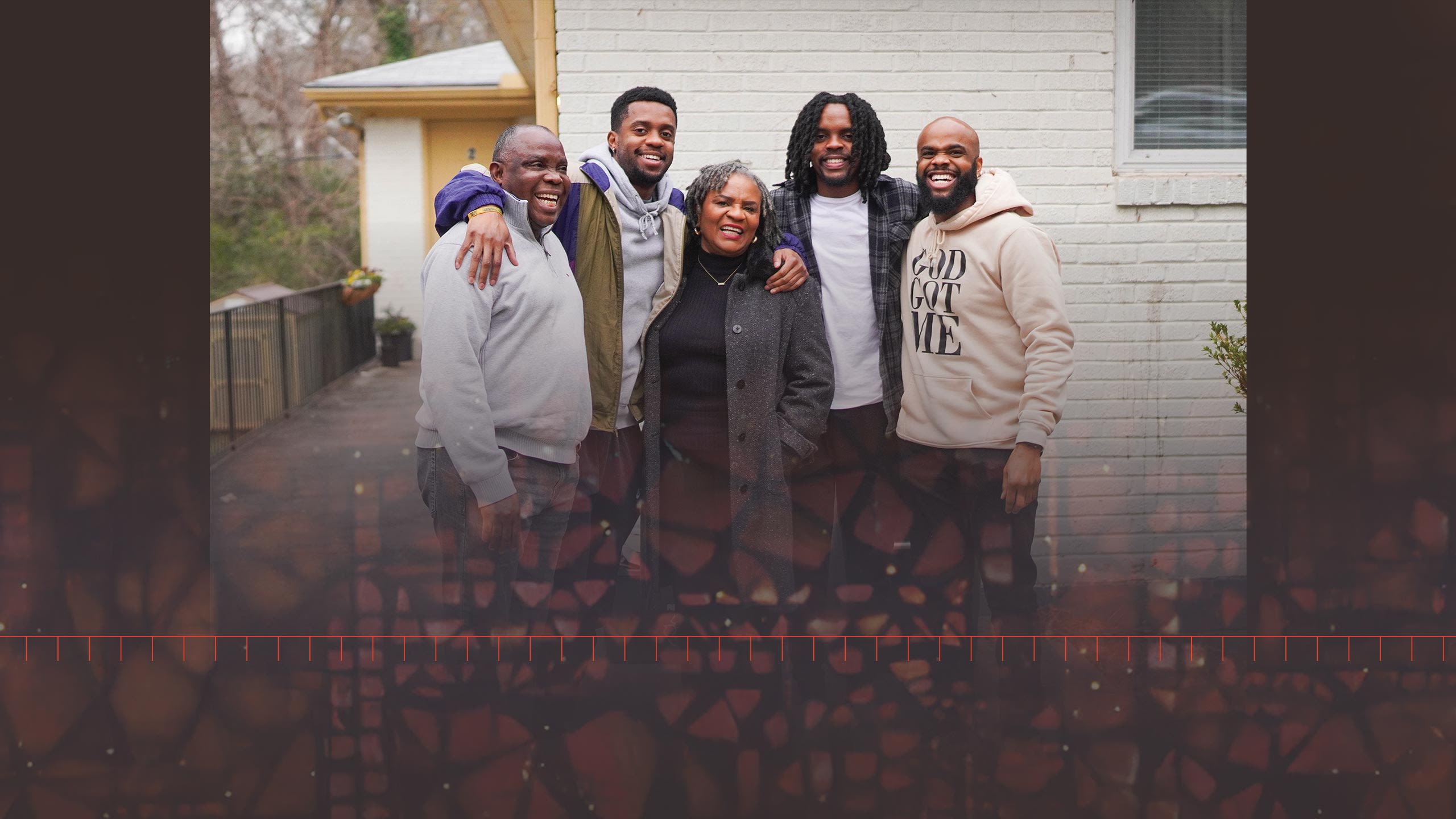 The George-Komi family stands smiling together outside their old apartment