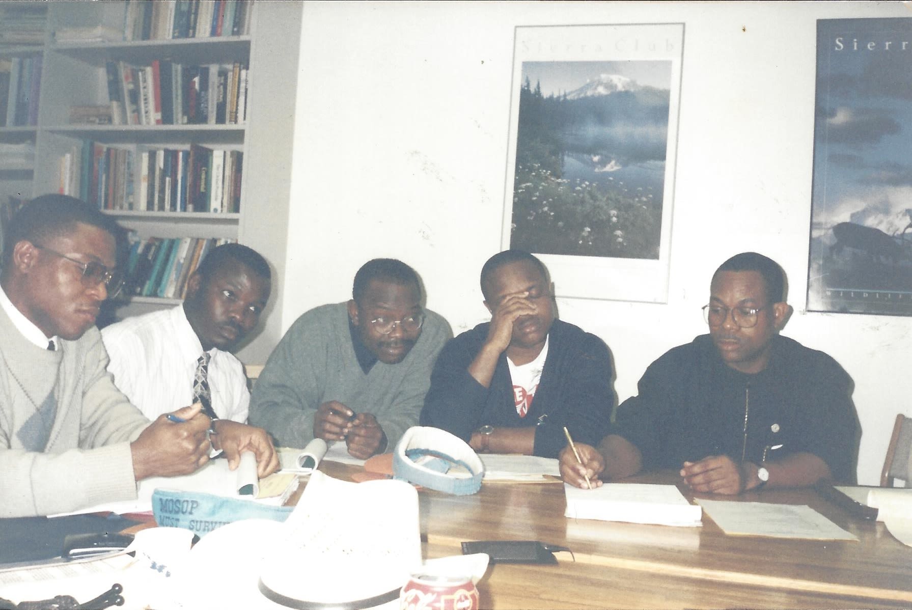 A group of Ogoni men sitting at a table working on important problems