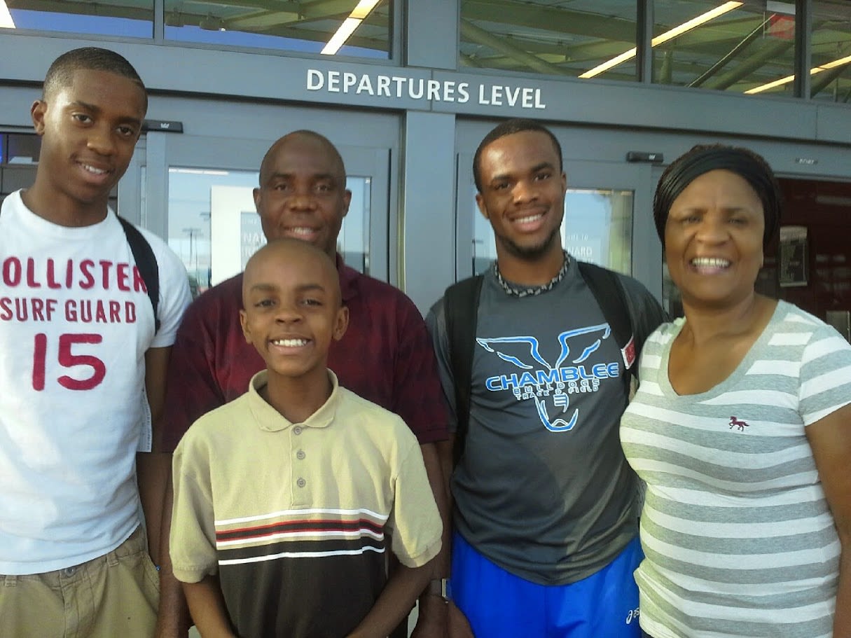 A father, a mother, and three sons outside an airport.